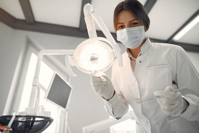 Woman in a uniform. Doctor working at the clinic. Dentist holds a tools in her hands