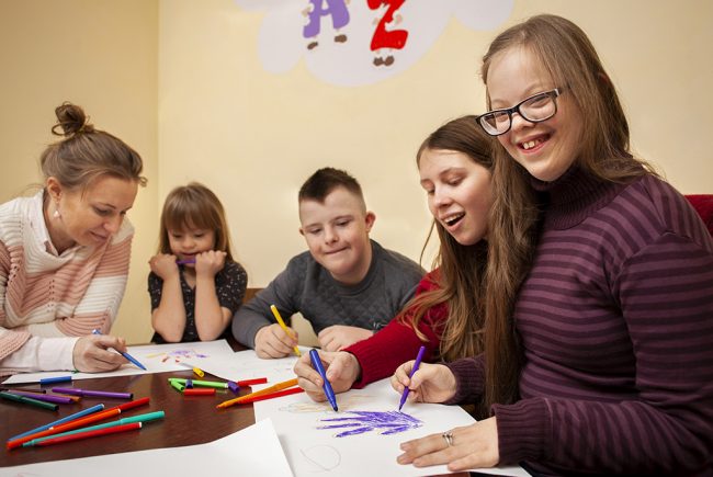 happy-girl-with-down-syndrome-posing-while-drawing