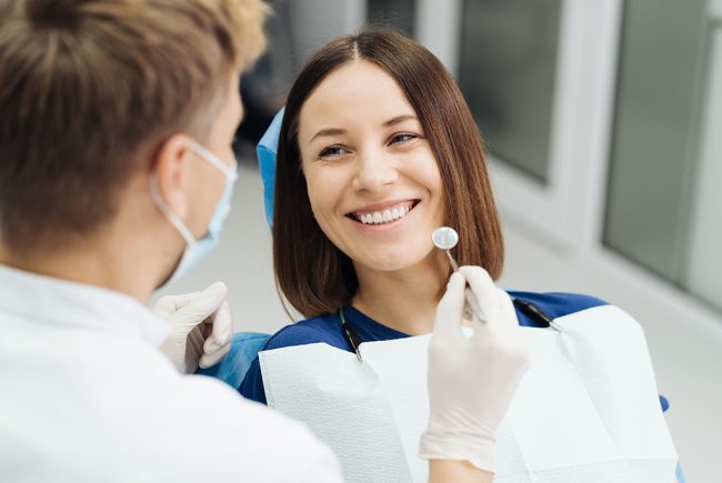 Male Professional Dentist With Gloves And Mask And Discuss What The Treatment Will Look Like Of The Patient's Teeth. Discussion Of The Treatment Plan And Healthy Smile