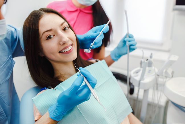 Assistant dentist and the patient in the clinic.