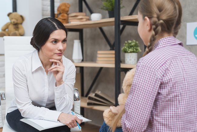 young-psychologist-observing-little-girl-sitting-in-front-of-her